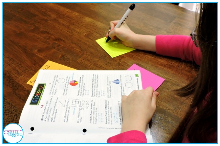 A child is defining the key vocabulary terms using a glossary.